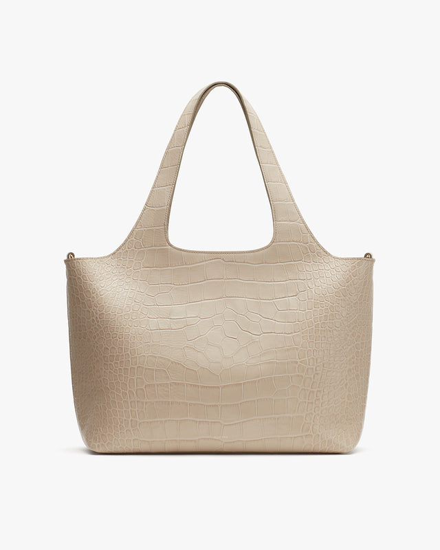 Handbag with two handles and textured surface.