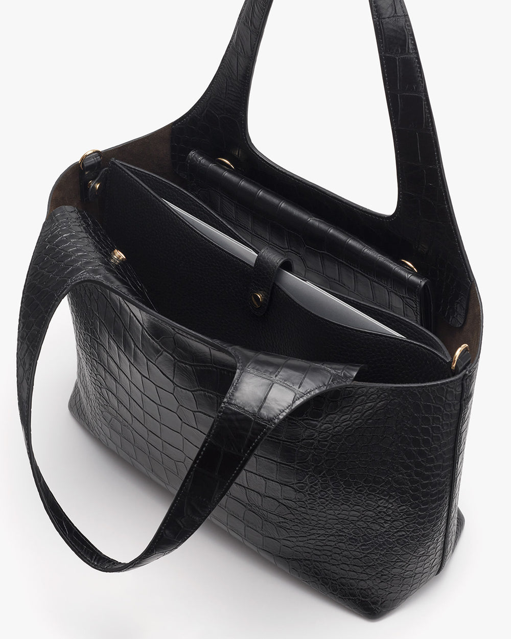 Open handbag with a laptop and notebook inside.