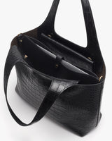 Open handbag with a book and tablet inside.