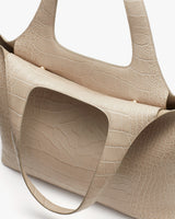 Two tote bags with textured exteriors standing next to each other.
