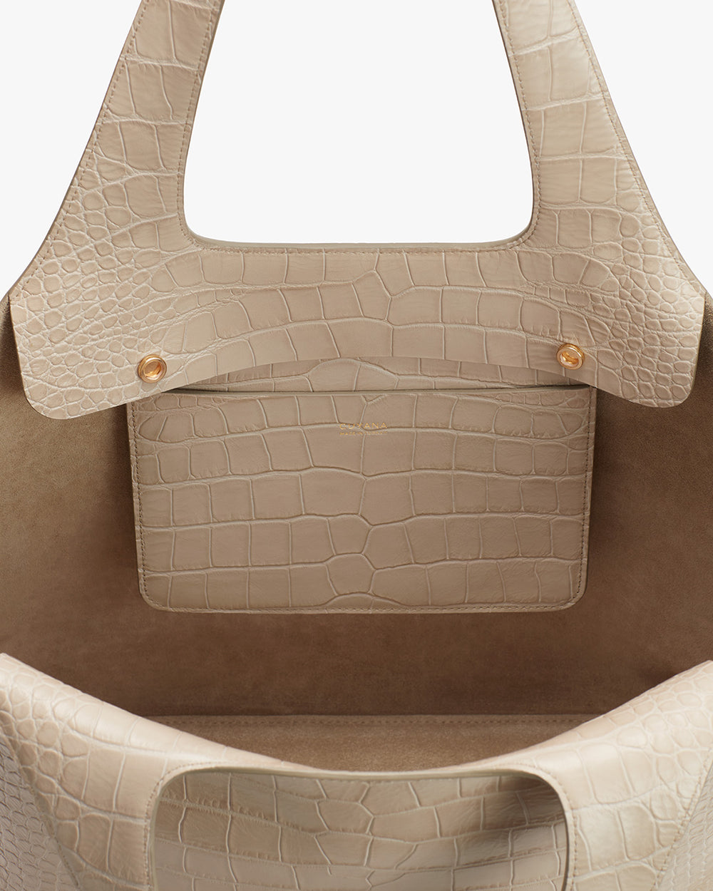 Beige handbag with textured exterior and inner pocket.