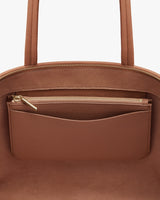 Close-up of a handbag with zipper and external pocket.