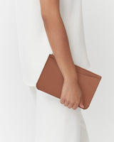 Person holding a small clutch bag with one hand.