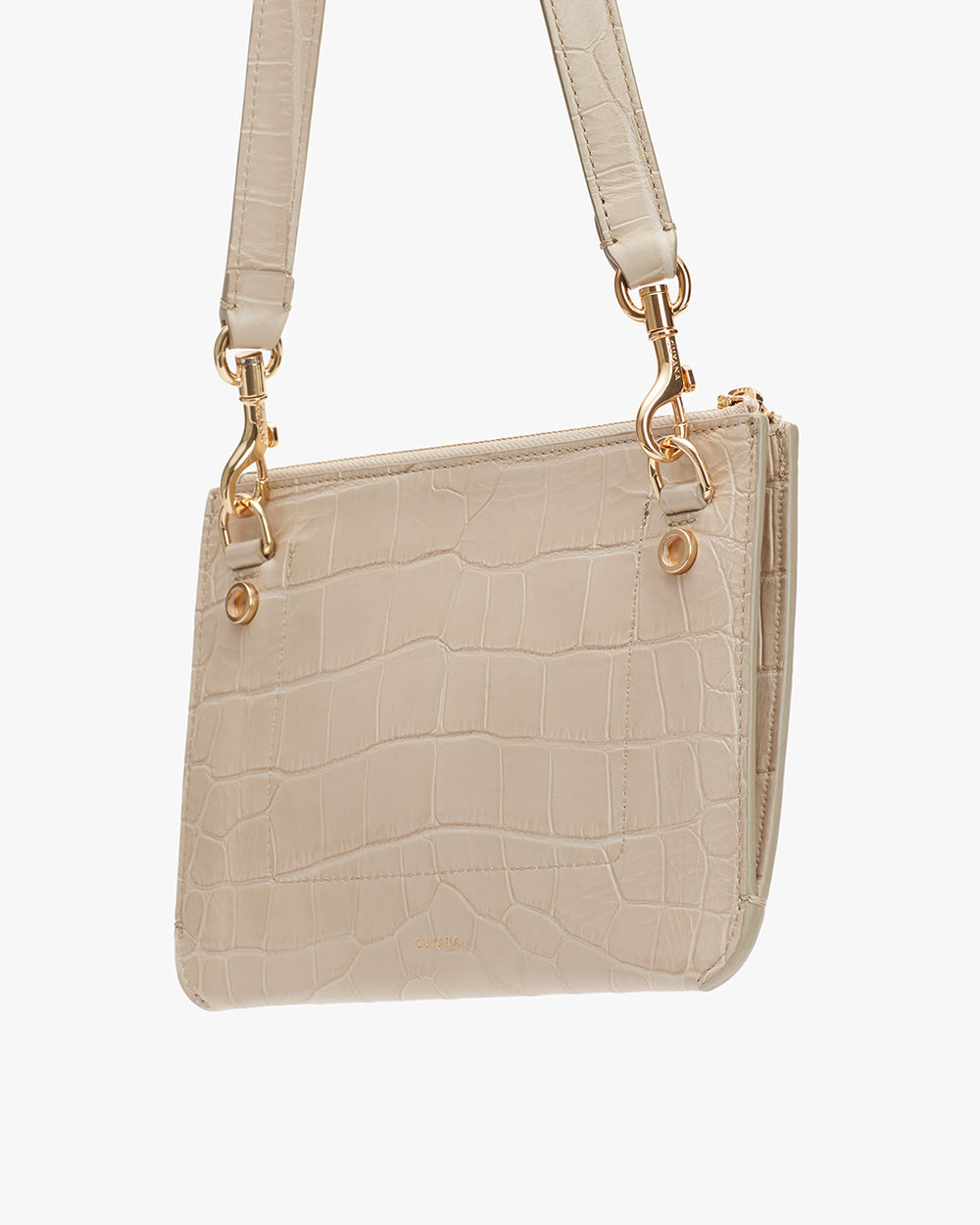 Handbag with strap and clasp details hanging against a solid background.