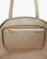 Handbag with an exterior pocket and zippers