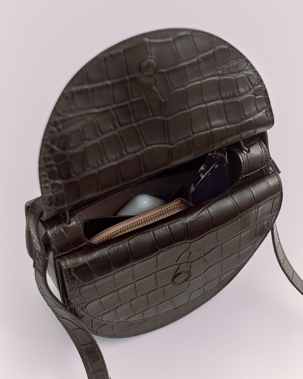 Double Moon Saddle Bag (Croco) Open croc-embossed leather bag with visible zipper pouch and sunglass.