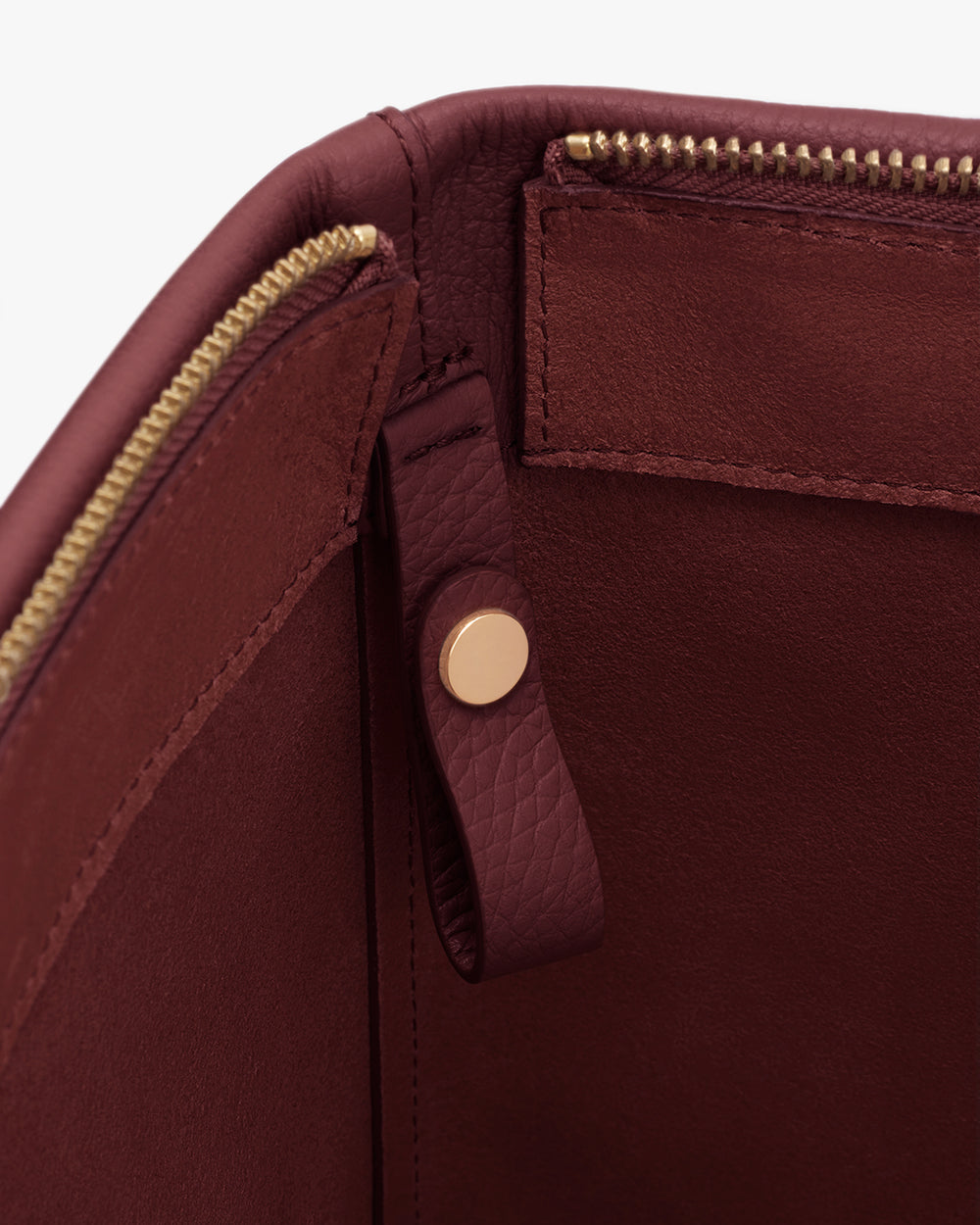 Open bag with zipper and button clasp interior.