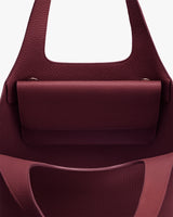 Open handbag with interior compartment and folded flap.