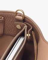 Open handbag showing interior compartments and metal hardware detailing