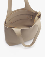 Open handbag with top handles and an inner pocket featuring a zipper and gold hardware.