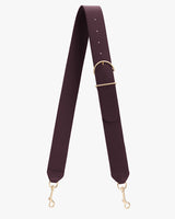 Adjustable bag strap with metal clasps and a buckle.