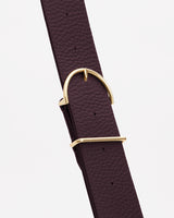 Textured leather strap with a shiny metal buckle and loop.