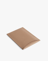 Rectangular leather laptop sleeve with a curved flap closure.