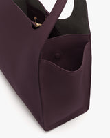 Tote bag with open pocket and handle, showing interior details.