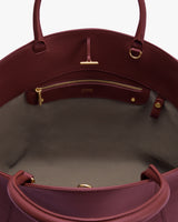 Open handbag with visible interior zip pocket and handles.