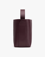 Tall leather bag with a single handle on top.