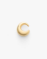 Small crescent-shaped metallic ear cuff on plain background.