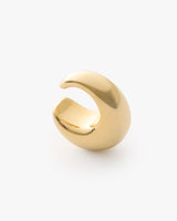 Small crescent-shaped metallic ear cuff on plain background.