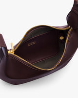 Open leather bag showing interior and zipper with brand name visible inside.