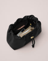 Open purse with contents inside including a phone, wallet, and a small pouch.