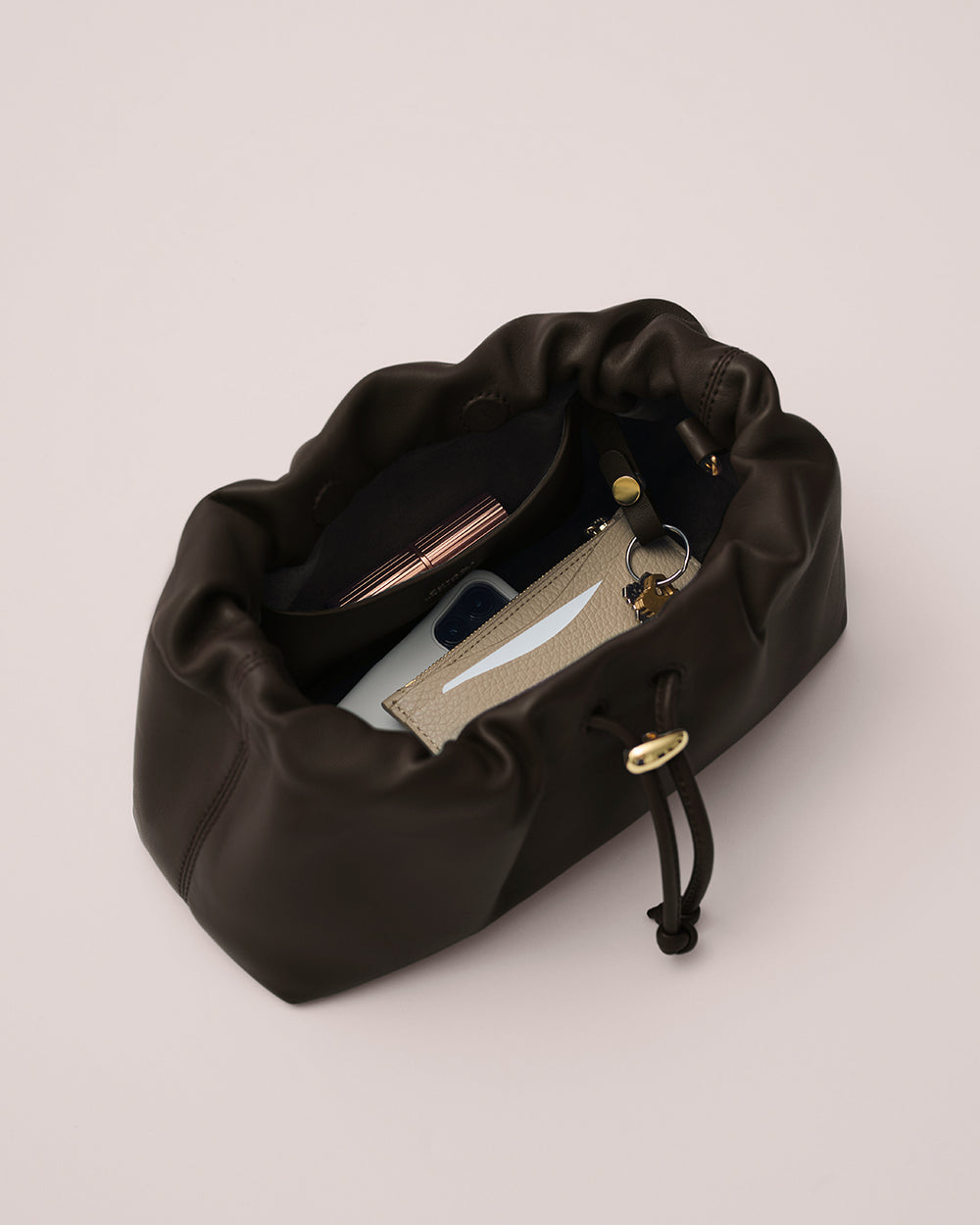 Mini Dia Bag Open bag with keys, phone, and wallet inside.