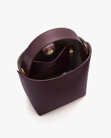 Open top view of a handbag with a clasp and inner pocket.