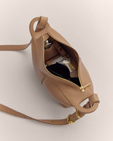 Inside view of an open leather bag with keys and sunglasses inside