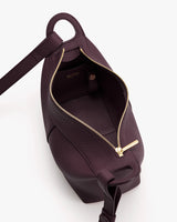 Open handbag shown from above with zipper and strap visible