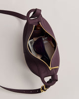 Open handbag with sunglasses, lipstick, phone, and keys inside.