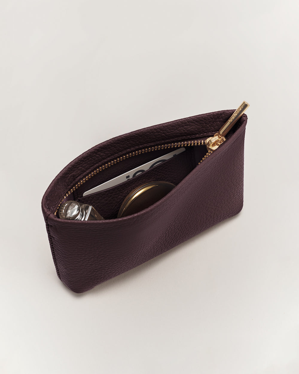 Small open pouch with items including a card and a container