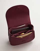 Open bag with compartments showing a phone and small items inside