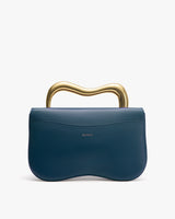 Handbag with unique wavy metal handle and curved flap design.