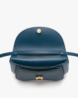 Open handbag with flap and button clasp, showing interior.