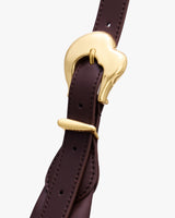 Close-up of a leather strap with a gold buckle.