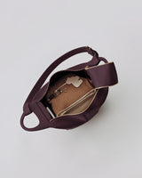 Open handbag showing contents including a wallet, keys, and a small pouch.