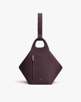 Geometric handbag with single strap and front zipper pocket.