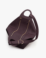A handbag with a top handle, zippers, and adjustable strap.