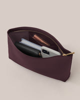 Open pouch with phone, wallet, notebook, and lipstick inside