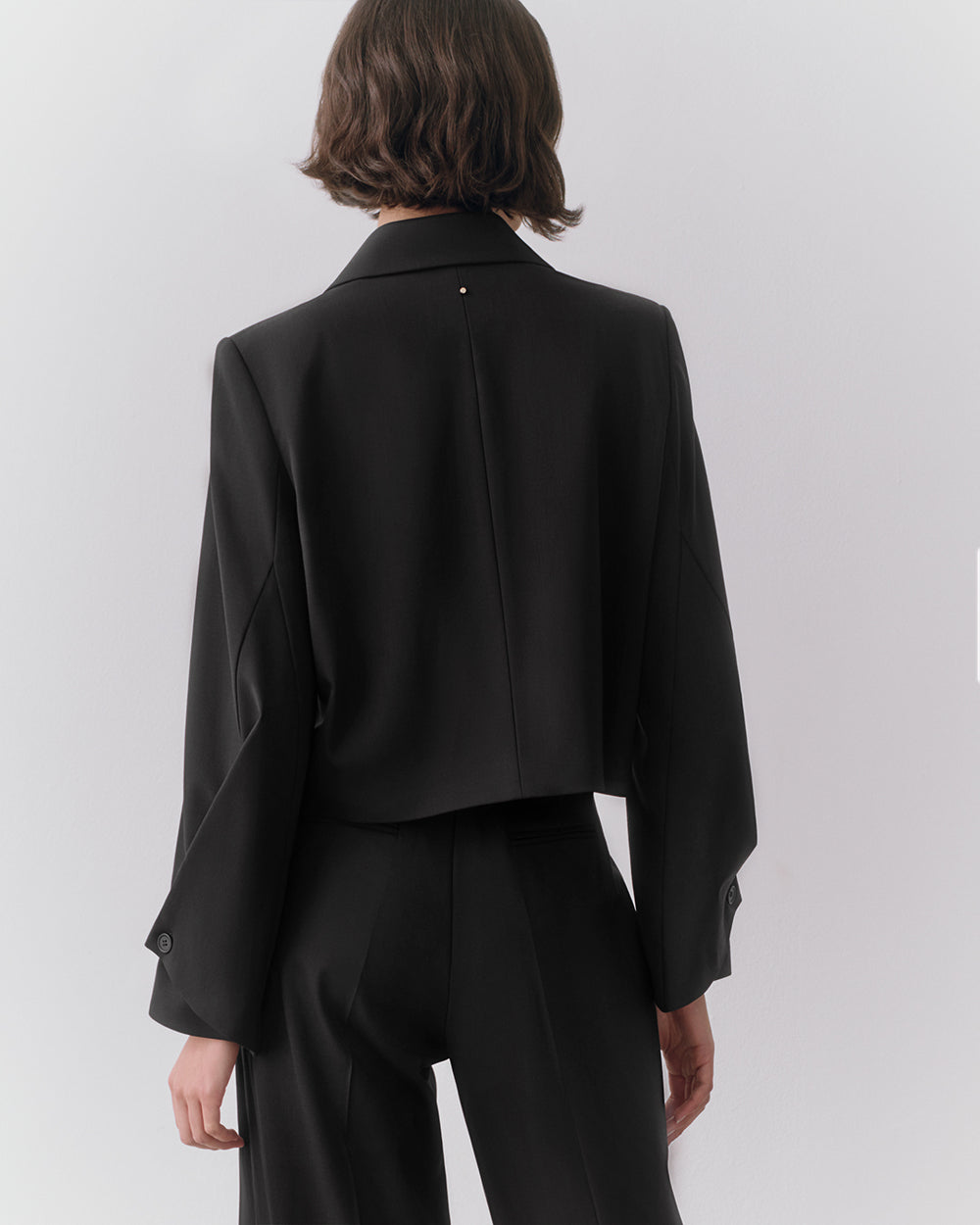 Wool Cropped Blazer Person wearing a suit viewed from the back