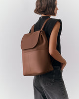 Person with backpack wearing sleeveless top and jeans