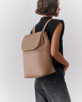 Person wearing sleeveless top and wearing a backpack.