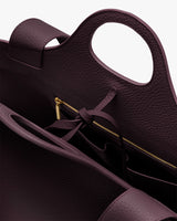 Open handbag showing handle and zippered pocket inside