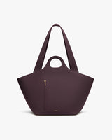 Handbag with zipper pocket and circular handle cutout