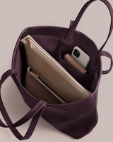 Open tote bag with phone and zip pouches inside.