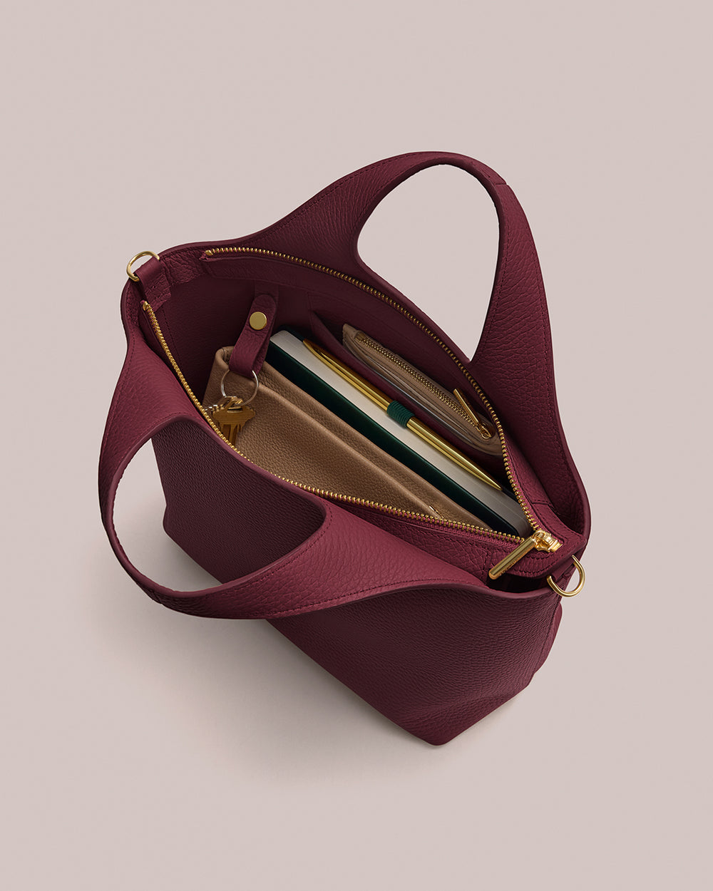 Small System Zipper Tote Open handbag with a notebook, pen, and a pouch inside