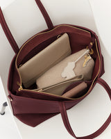 Open handbag with keys, pouches, and wallet inside.