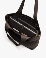 Open tote bag with a laptop, glasses, and a small pouch inside.