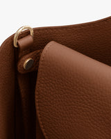 Close-up of a textured leather laptop sleeve with metal clasp detail.