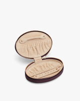 Open oval jewelry case with compartments and elastic holders.