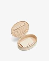 Open round jewelry case with a small pouch inside.